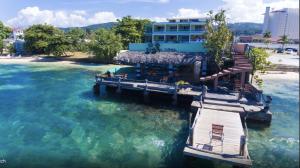 a dock in the water in front of a building at Ocean Palms in Ocho Rios