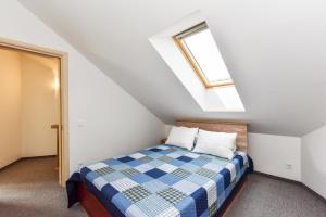 a bedroom with a bed and a skylight at Vila GULBĖS TAKAS in Šventoji