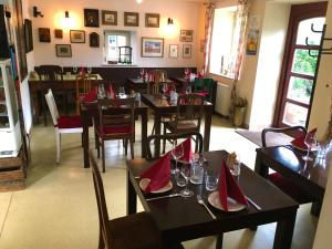 ein Restaurant mit Holztischen und -stühlen und roten Servietten in der Unterkunft Freistaat Eifel in Nettersheim