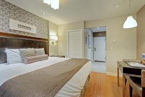 een slaapkamer met een groot bed en een bureau bij Helm's Inn in Victoria