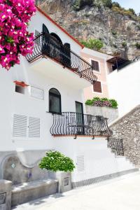 a white building with stairs and balconies with flowers at Gema Suites in Positano