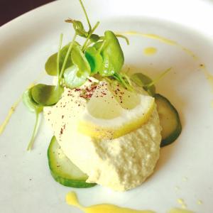 a plate of food with a piece of fish with cucumbers at Freistaat Eifel in Nettersheim +13 photos