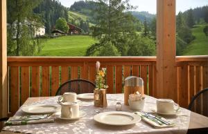 einen Tisch mit Tellern und Küchenutensilien auf einer Veranda mit Aussicht in der Unterkunft Residence Lersc in Abtei