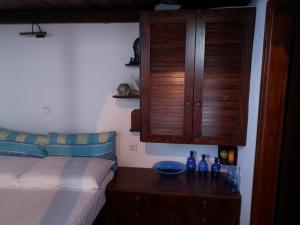 a bedroom with a bed and a wooden cabinet at Glaros in Pera Gyalos