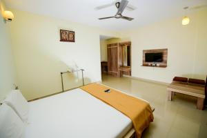 a white bedroom with a bed and a couch at Shesha KUTEERA in Subrahmanya