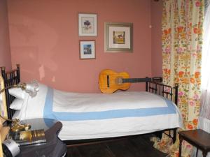 um quarto com uma cama com uma guitarra na parede em Whitmore em Lancaster