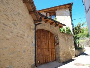 un edificio de piedra con puerta de madera en O´Porron, en Sabiñánigo