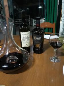 dos botellas de vino y una copa en una mesa en Resort Te Zagolli en Orikum