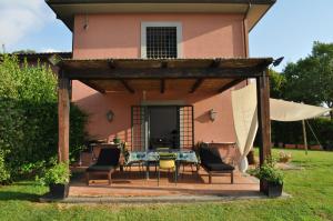 um pátio com uma mesa e cadeiras em frente a uma casa em Casale Vicino Al Golf Nazionale em Monterosi