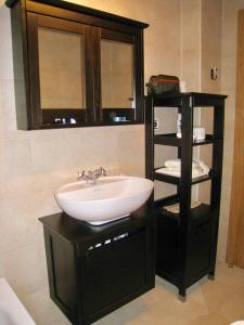 un bagno con lavandino e specchio di Acogedor apartamento en el corazón del Valle a Les Bordes