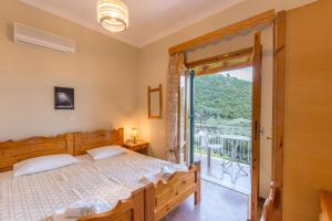 a bedroom with a large bed and a balcony at Villa Maria Makri in Paleokastritsa
