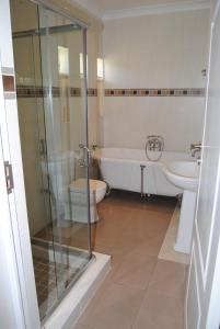 ein Badezimmer mit einer Badewanne, einem WC und einem Waschbecken in der Unterkunft Villa D este in Kimberley