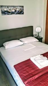 a large white bed with a red blanket on it at Tony Central Luxury Apartment 1 in Chania