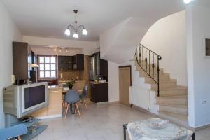 a living room with a tv and a staircase at Cosy House in Palekastron