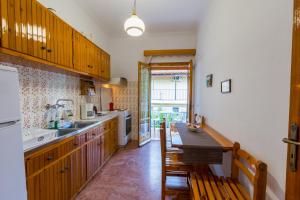 a kitchen with wooden cabinets and a wooden table at Villa Maria Makri in Paleokastritsa