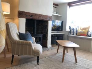 a living room with a chair and a fireplace at Goose Cottage in Marlborough