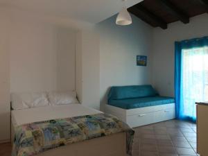 a bedroom with a bed and a couch and a window at PRETTY LITTLE HOUSE (con piscina e wi-fi) in Nebida