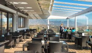 a row of tables and chairs on a balcony at Modern Ground Floor Calanova Golf Apartment in La Cala de Mijas