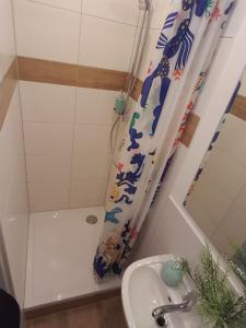 a bathroom with a shower curtain and a sink at Pension Moserhaus in Harburg