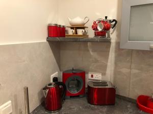 a kitchen with two red appliances on a counter at Marsascala Sea View Apartment & Penthouse in Marsaskala
