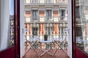 a table and chairs on a balcony with a building at Fuencarral Boutique in Madrid