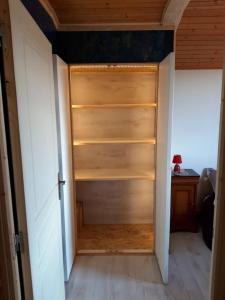 Habitación con armario con estanterías de madera. en Home for Geeks, en Le Bélieu