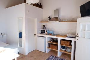 uma pequena cozinha com um balcão e um micro-ondas em Casas de Mértola 32 em Mértola