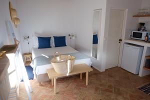 Un dormitorio con una cama con almohadas azules y una mesa. en Casas de Mértola 32, en Mértola