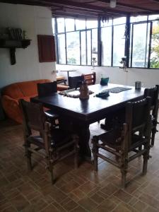 a dining room with a wooden table and chairs at Los Tres Leones in Salento