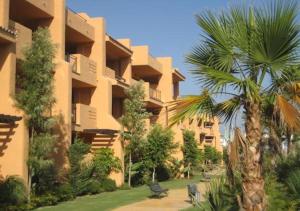a building with a palm tree in front of it at Modern Ground Floor Calanova Golf Apartment in La Cala de Mijas