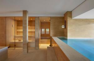 Alex Lake Zürich - Lifestyle hotel and suites في تالويل: منزل به مسبح وغرفة نوم