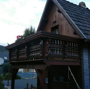 un edificio de madera con balcón en la parte superior. en Ferienwohnung Schelhorn, en Mengersgereuth-Hämmern