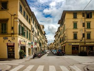 eine Stadtstraße mit Gebäuden und Autos auf der Straße in der Unterkunft Romantico Balcone in Centro in Florenz