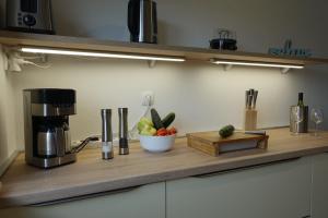 Klimatisiertes Apartment Barbara في تربانج: كونتر مع آلة صنع القهوة وصحن من الفاكهة