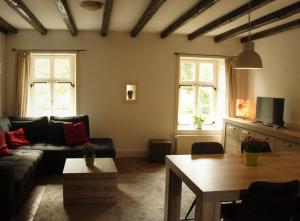 een woonkamer met een bank en een tafel bij Kasteel Schaloen in Valkenburg