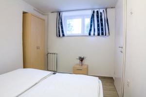 Schlafzimmer mit einem Bett und einem Fenster in der Unterkunft Apartments Bukovšek in Portorož