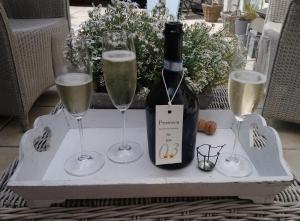 uma mesa com uma garrafa de champanhe e dois copos em Petit Bonheur em Oudenaarde