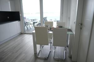 une salle à manger avec une table et des chaises blanches dans l'établissement Amazing View Apartments, à Nin