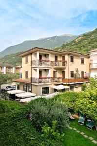 a large apartment building with a balcony and a yard at Hotel Erika in Malcesine