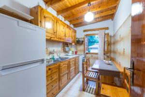 a kitchen with wooden cabinets and a table and a dining room at Villa Maria Makri in Paleokastritsa