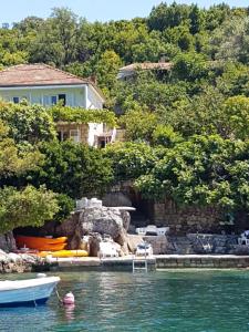 a house on the water with a boat in the water at Villa Lara in Molunat