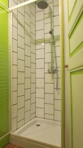 y baño con ducha de azulejos blancos. en B&B Les Paddocks, en Vollore-Montagne