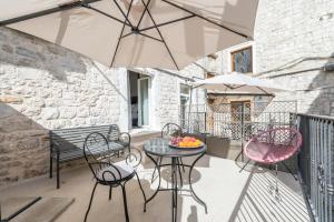 a patio with a table and chairs and an umbrella at Princ Heritage Rooms in Split