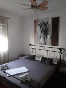 a bedroom with a bed with a keyboard and a fan at Apartman Astra in Ploče