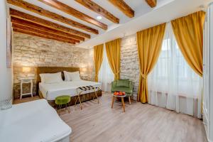 une chambre d'hôtel avec un lit, une chaise et des fenêtres dans l'établissement Princ Heritage Rooms, à Split