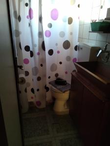 a bathroom with a toilet and a polka dot shower curtain at Elafonisi House in Livadia