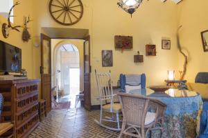 a living room with a table and chairs and a clock at Casa centenaria con encanto in Zufre