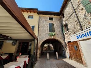 un accès à un bâtiment avec une arche dans l'établissement Appartamenti San Francesco, à Lazise