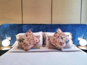 un letto con cuscini e testata blu di Renascentia in Florence - Adults Only a Firenze