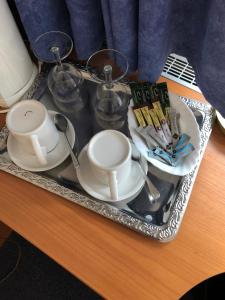 a tray with cups and dishes on a table at Gästehaus Am Vogelsang in Kerpen